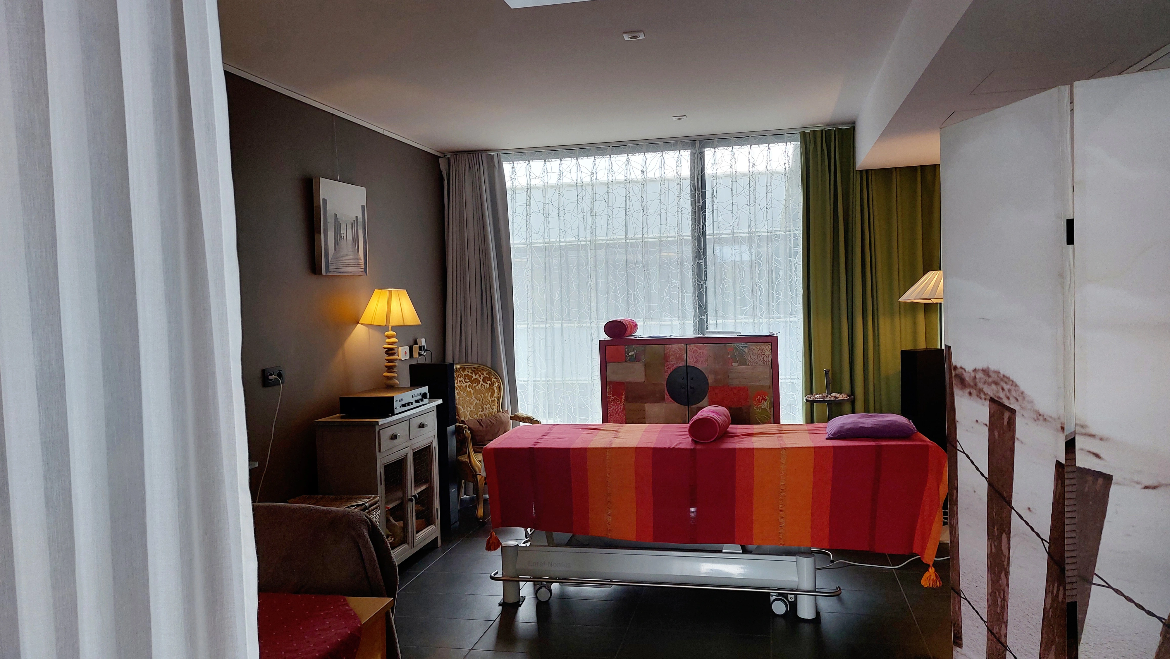 Ruimte met massagetafel, lampjes en kasten