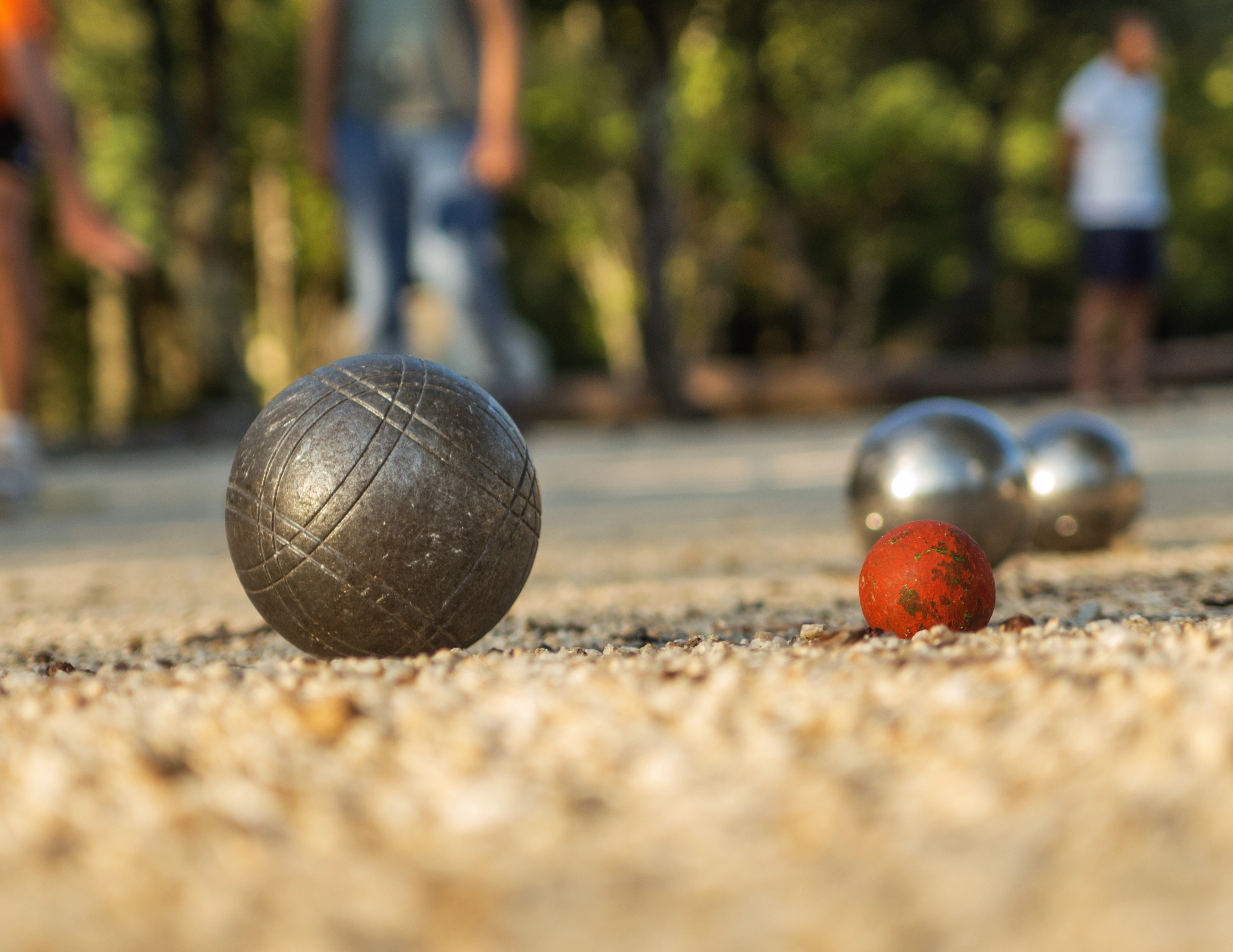 Petanqueballen op een petanqueveld met mensen op de achtergrond