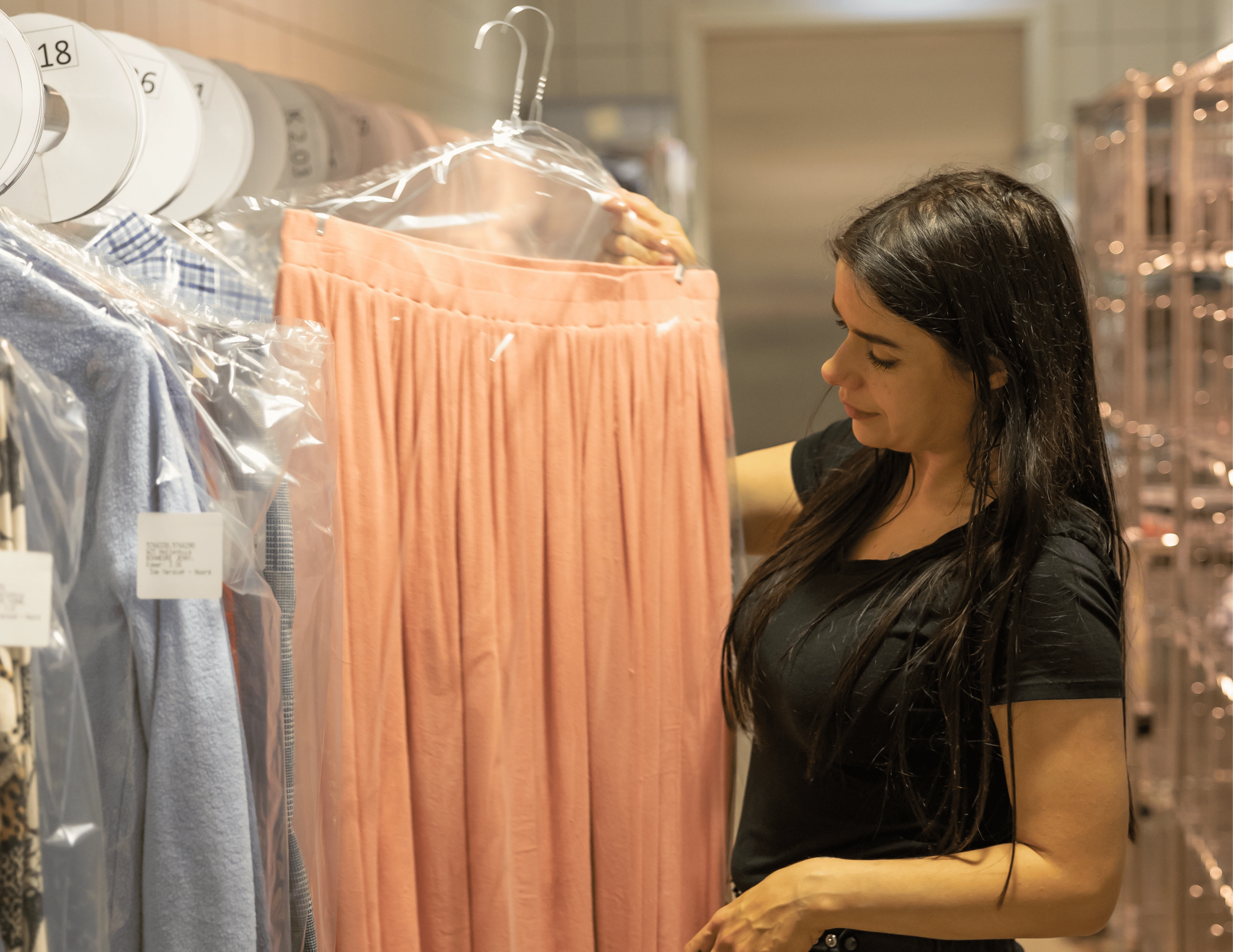 Vrouw in de wasserij houdt roze rok vast