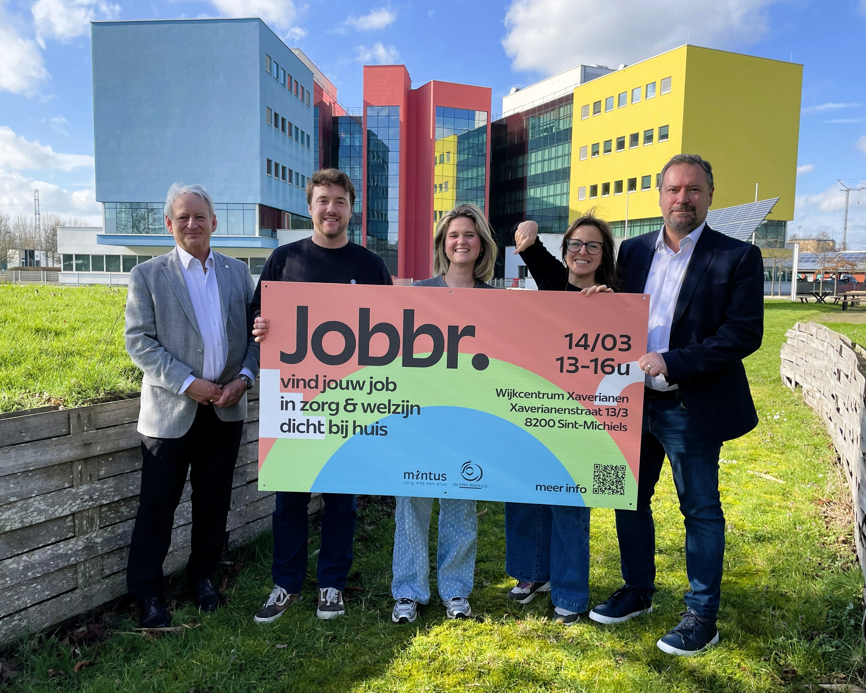 3 collega's van de personeeldienst OCMW/Mintus houden een reclamepaneel vast. Links staat algemeen directeur Christian Fillet. Recht staat Mintus-voorzitter Pablo Annys