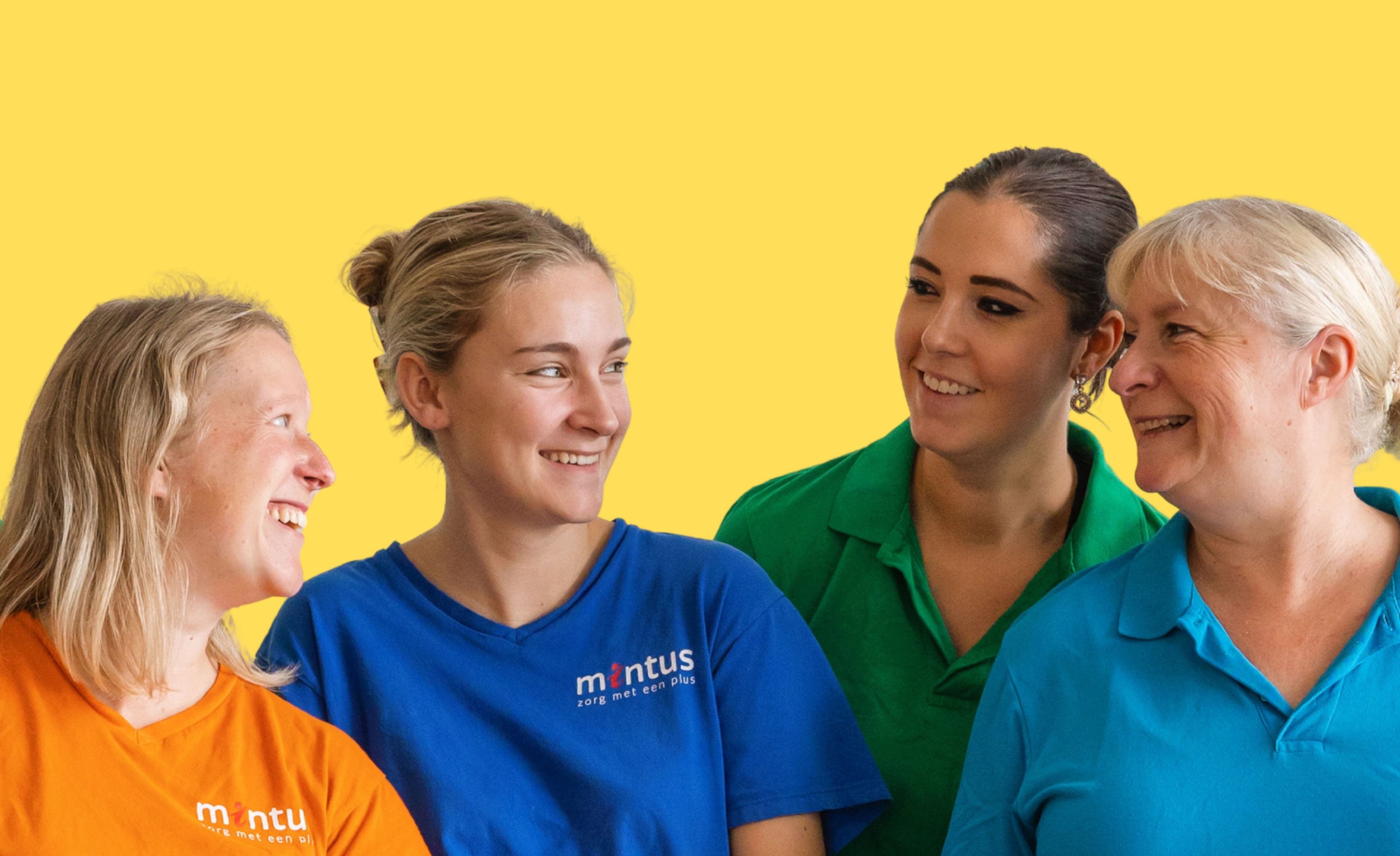 Mintus-medewerkers in kleurige t-shirts staan voor een gele muur. Ze kijken elkaar aan en lachen.