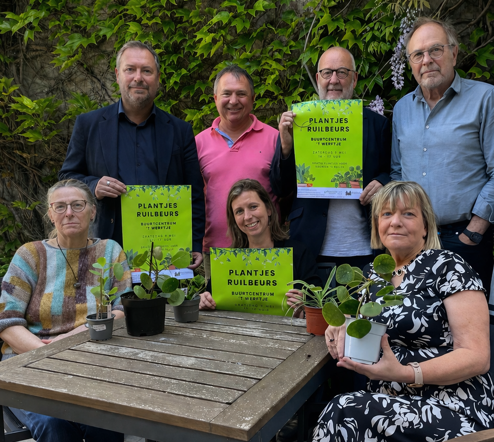 Schepen/voorzitter Mintus Pablo Annys (foto links boven) poseert samen met de organisatoren van de plantjesruilbeurs waarvan sommigen een reclameaffiche vasthouden.