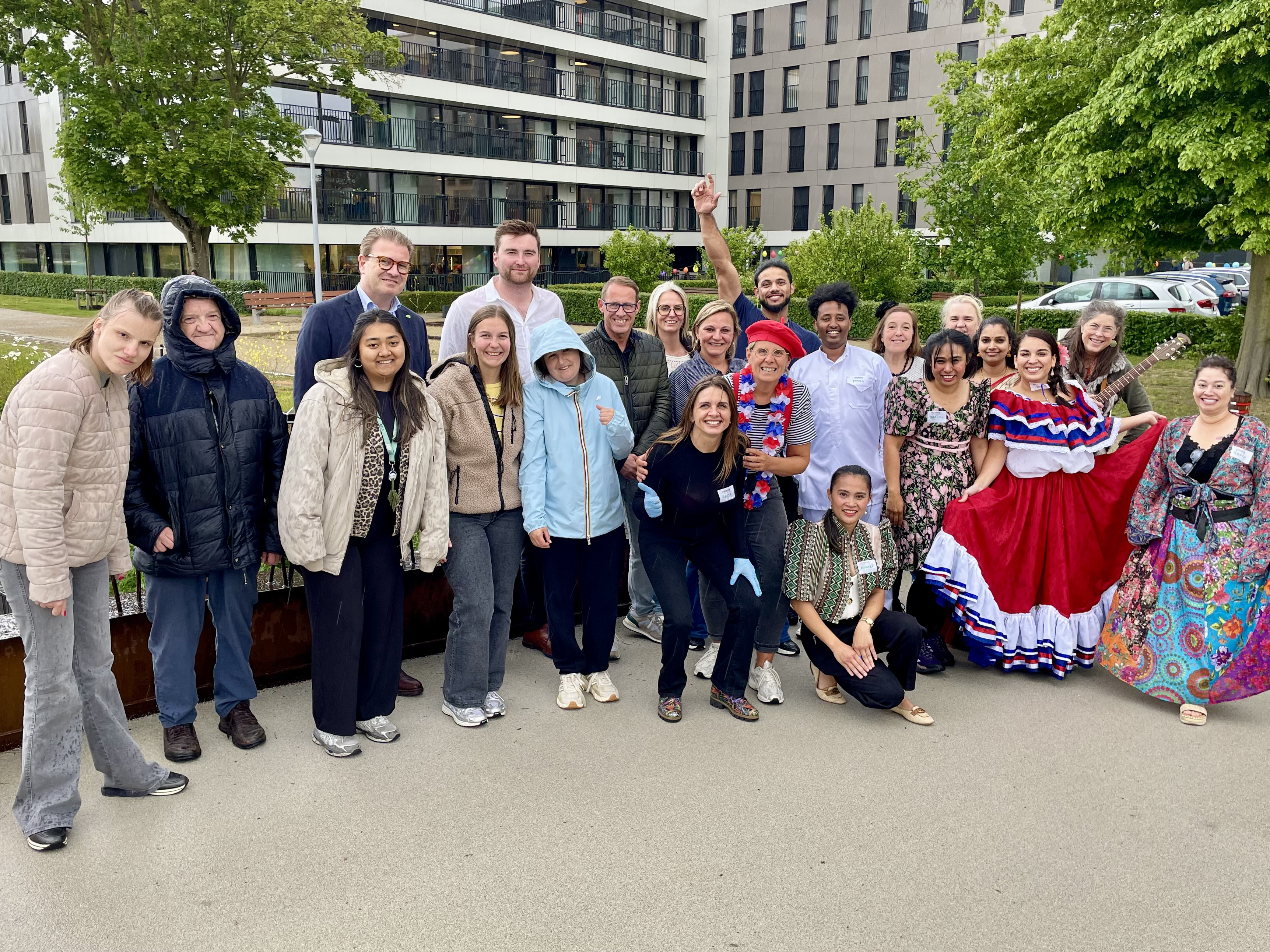 De organisatoren van het buurtfeest poseren samen met woonzorgcentrum Ten Boomgaarde op de achtergrond.